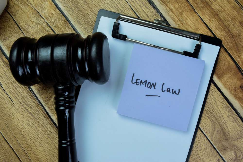 Concept of Lemon Law write on sticky notes with gavel isolated on Wooden Table.